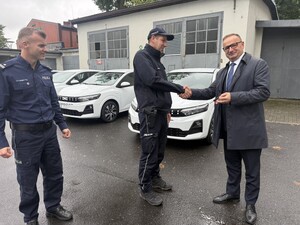 Na zdjęciu widać policjanta oraz Prezydenta Miasta a w tle biały samochód.