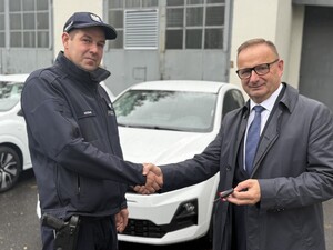 Na zdjęciu widać policjanta oraz Prezydenta Miasta a w tle biały samochód.