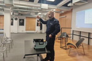 Na zdjęciu widać policjanta oraz uczestników spotkania.