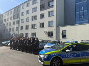 Na zdjęciu widać policjantów i policjantki żorskiej komendy Policji zgromadzonych na parkingu przed budynkiem i oddający honor poległemu koledze.