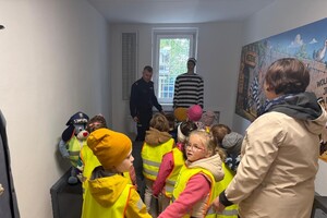 Na zdjęciu widać przedszkolaki oraz policjantów.