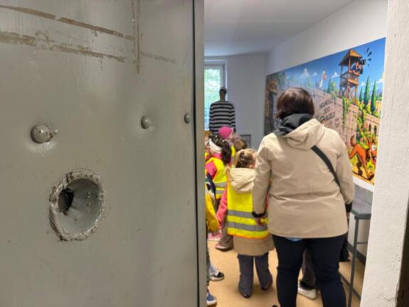 Na zdjęciu widać przedszkolaki oraz policjantów.