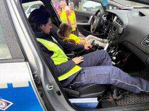 Na zdjęciu widać przedszkolaki oraz policjantów.