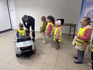 Na zdjęciu widać przedszkolaki oraz policjantów.