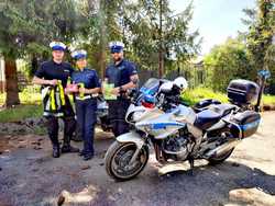 zdjęcie kolorowe policjanci motocykliści i policjantka stoją obok motorów